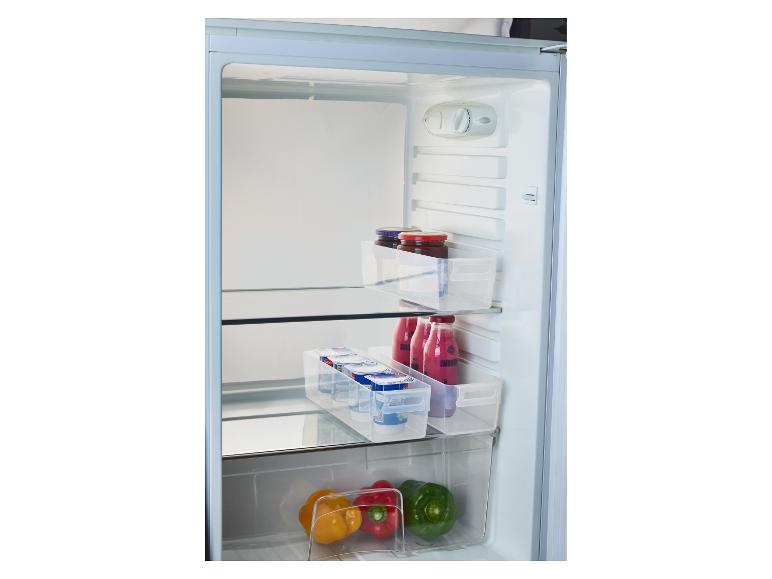 Intérieur d'un réfrigérateur avec des pots de confiture, des yaourts, des smoothies et des poivrons dans des récipients transparents.