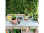 Table de jardin avec des plantes, des outils et de la terre.
