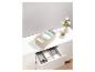 Boîtes de rangement pour vêtements dans une commode blanche.