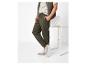 Homme en pantalon de survêtement vert olive, t-shirt beige et baskets grises.