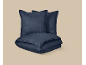 Parure de lit en satin bleu foncé à rayures, composée d'une housse de couette et de deux taies d'oreiller.