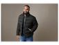 Un homme avec une veste matelassée noire et un jean.