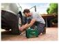 Un homme utilise un compresseur Parkside pour gonfler un pneu de voiture.