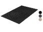 Paillasson rectangulaire noir avec un motif géométrique de lignes et de demi-cercles.