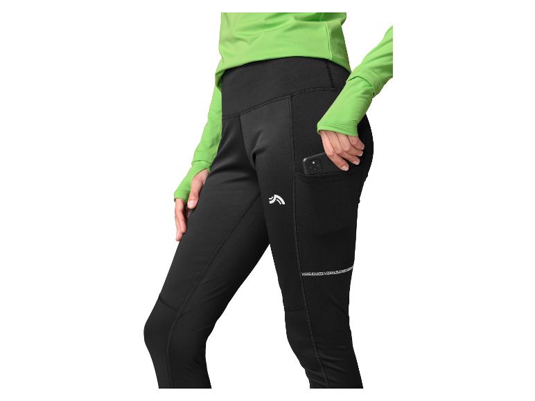 Femme en leggings de course noirs avec poche latérale et haut vert.