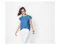 Femme en t-shirt bleu à volants et pantalon blanc, lunettes de soleil et bracelets.