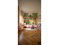 Chambre d'enfant avec lit cabane, papier peint forêt et petite fille qui lit.