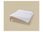 Couette blanche sur un cadre de lit en bois avec un drap beige.
