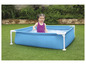 Une petite fille joue dans une piscine gonflable dans le jardin.