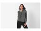 Une femme porte un cardigan gris en tricot boutonné et un pantalon noir.