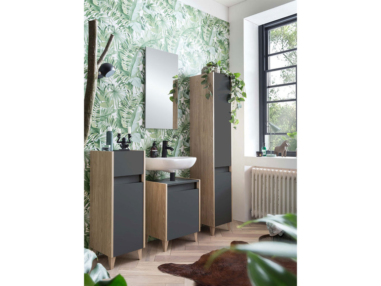 Meubles de salle de bain avec miroir, lavabo et deux armoires dans un environnement tropical.