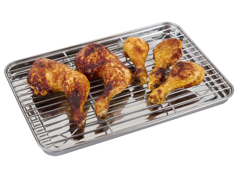 Cuisses et pilons de poulet grillés sur une grille métallique.