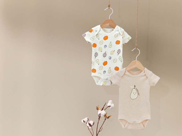 Deux bodies de bébé avec un imprimé de fruits, l'un avec des poires et l'autre avec un motif de poire.