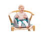 Bébé assis dans une chaise haute avec harnais de sécurité.