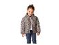 Fille souriante en doudoune beige à pois et jean bleu foncé.