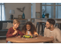 Des enfants et un homme assemblent un puzzle 3D vert de voiture de sport à table.