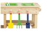 Une table de jeu en bois avec deux bacs verts et trois outils de jardin colorés.