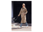 Femme en trench-coat beige et baskets blanches porte un sac à bandoulière noir.