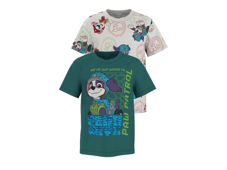 Deux t-shirts pour enfants, l'un blanc à motifs de chiots et l'autre vert avec un chiot et le texte 'WE'VE GOT DINOS TO SAVE! PAW PATROL'.