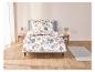 Un lit avec une couette blanche à motifs floraux.