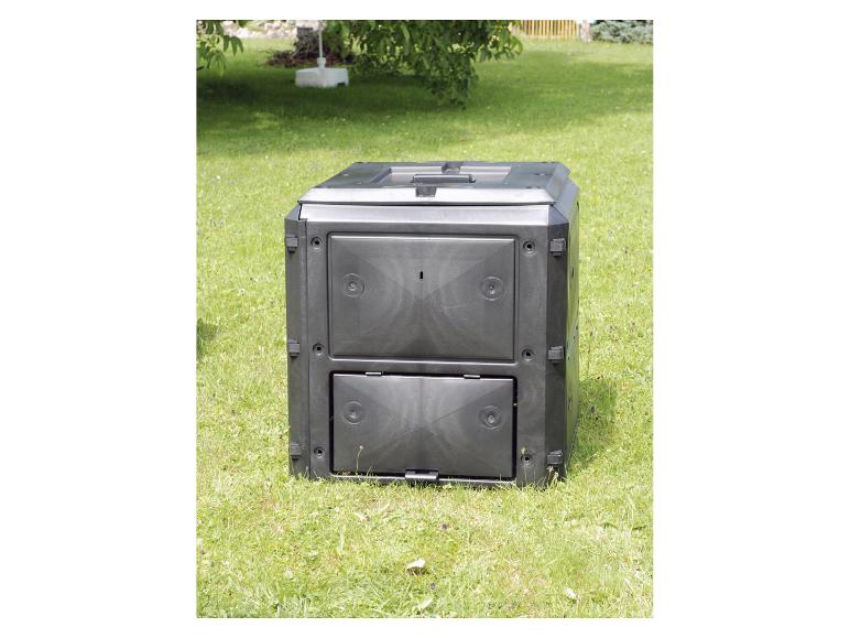 Composteur de jardin noir sur herbe verte