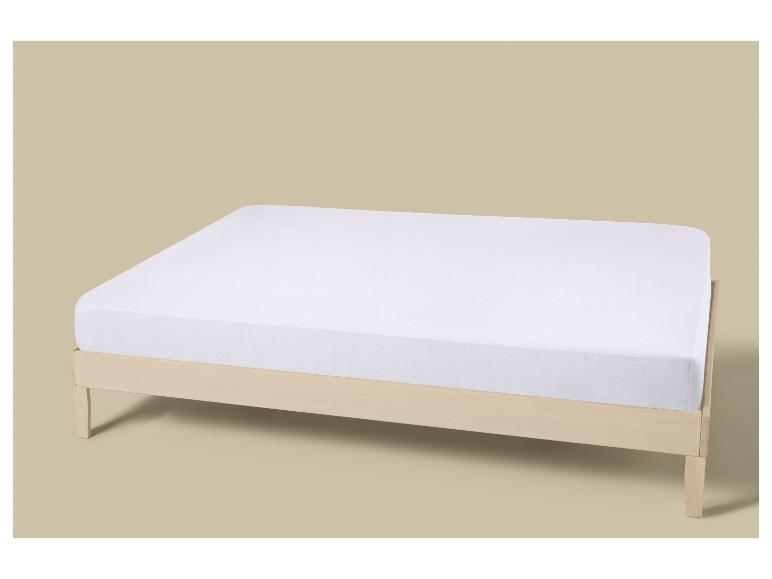 Matelas blanc sur un cadre de lit en bois