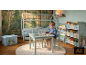 Chambre d'enfant avec lit cabane, table et chaises, étagères et boîte de rangement, thème forêt.