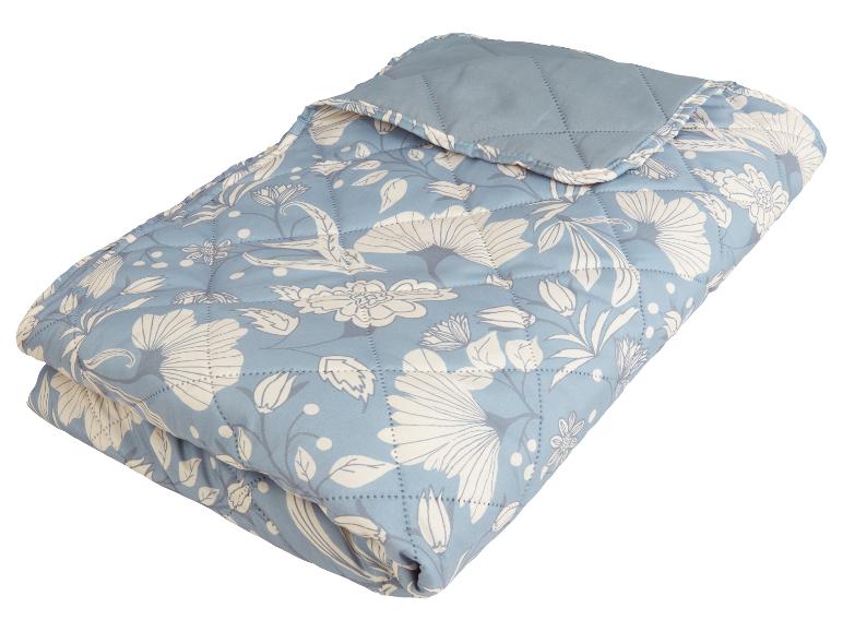 Couette matelassée bleu clair à motifs floraux.
