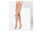 Femme portant des collants nude transparents, debout à côté d'un bloc blanc.