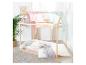 Lit cabane en bois avec baldaquin rose et bleu, plantes et art mural.