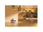 Aspirateur robot avec station de charge dans une cuisine moderne avec un chat.