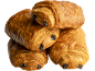 Quatre pains au chocolat dorés et croustillants, empilés sur fond noir.