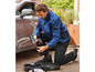 Un homme utilise un tournevis Parkside pour travailler sur une voiture.