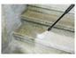 Un nettoyeur haute pression nettoie un escalier en béton.