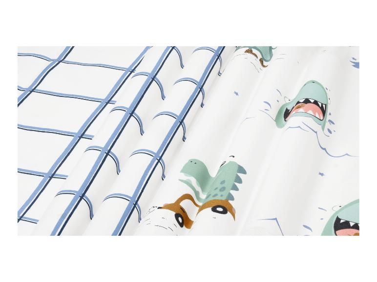 Tissu blanc avec motif à carreaux bleus et dinosaures de dessins animés.