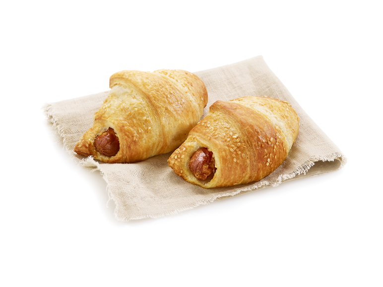 Deux croissants salés aux saucisses, sur un torchon en lin.