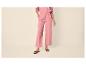 Pantalon large rose pour femme avec sandales plates noires.