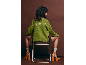Femme de dos portant un pull vert avec texte et des talons orange.