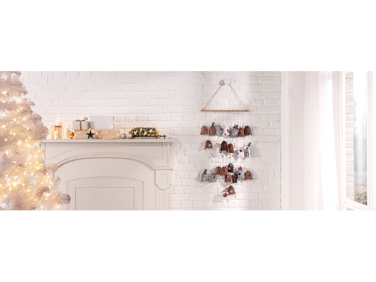Calendrier de l'avent en tissu avec petites pochettes, décorations de Noël et bougies festives.