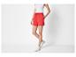 Shorts rouges et baskets blanches pour femme.
