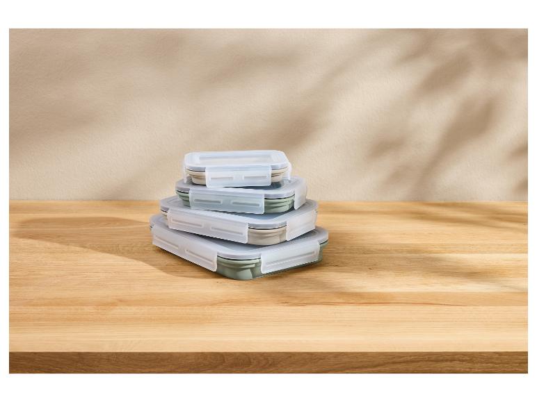 Pile de boîtes à lunch pliables de différentes tailles sur une table en bois.