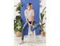 Une femme en pull rose et en jean bleu porte des baskets.