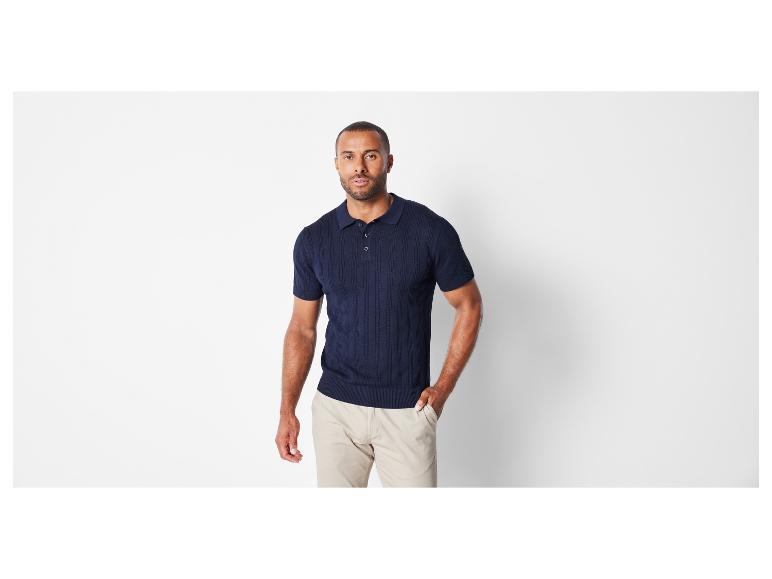 Un homme portant un polo bleu marine et un pantalon beige.