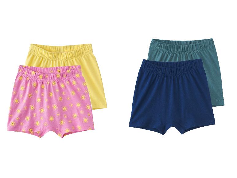 Deux paires de boxers pour enfants: un rose avec des soleils et un jaune, et un bleu marine avec un sarcelle.