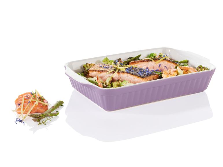 Saumon grillé avec des asperges et du brocoli dans un plat à gratin violet.