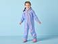 Une fille porte un imperméable bleu à capuche et des bottes de pluie.