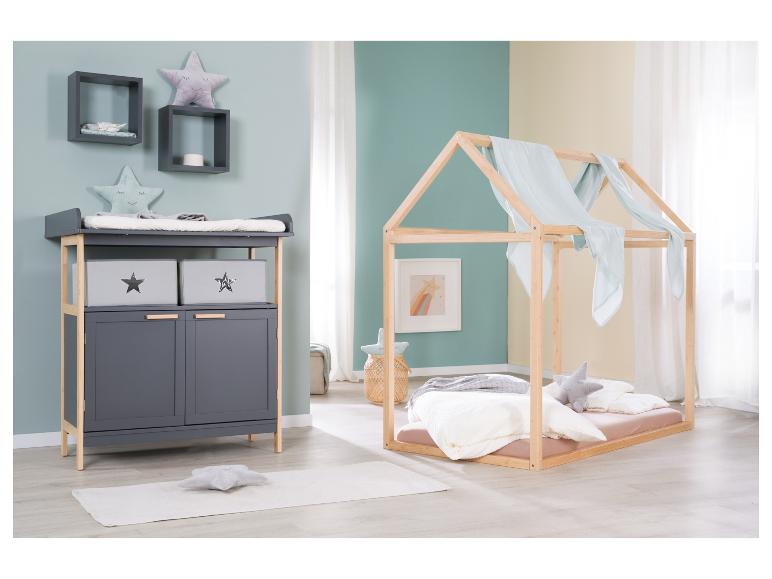 Chambre d'enfant avec table à langer et lit cabane en bois.