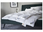 Une couette blanche Fjodur sur un lit vert foncé.