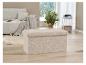 Un banc de rangement beige avec un revêtement doux et moelleux dans un salon moderne.