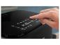 Main touchant l'écran tactile d'une friteuse à air Philips noire.